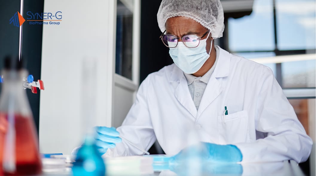 Scientist wearing protective gear conducting lab tests in a sterile pharmaceutical environment.