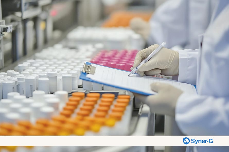 Technician documenting sample handling during CMC manufacturing with labeled pharmaceutical containers arranged in a controlled production environment.