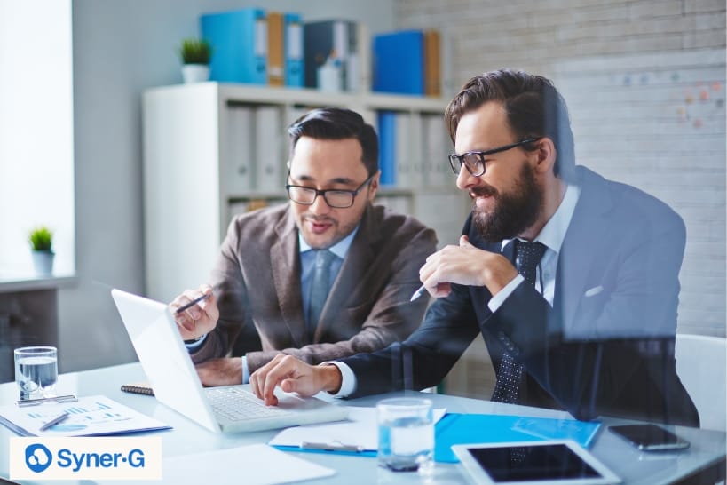 Biopharma strategy consultants reviewing data on a laptop during a collaborative meeting for pharmaceutical planning, development, and advisory services