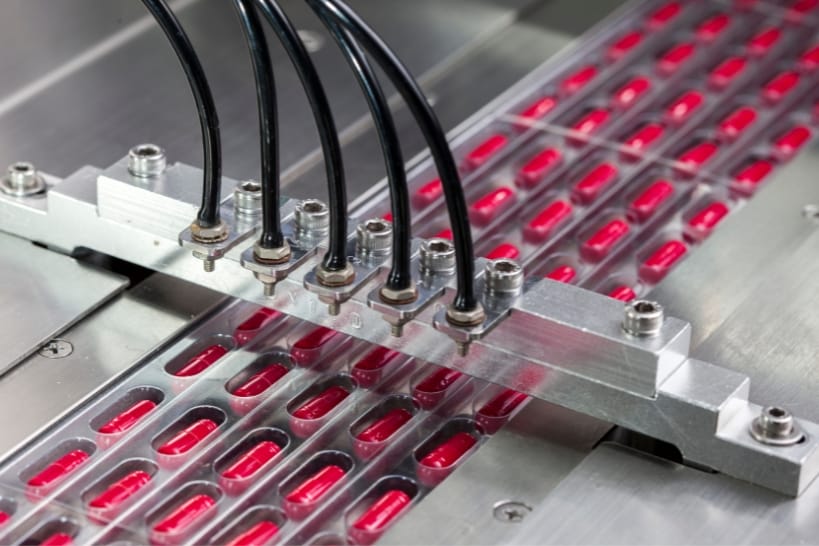 Automated biologics CDMO production line manufacturing capsule-based pharmaceutical products.