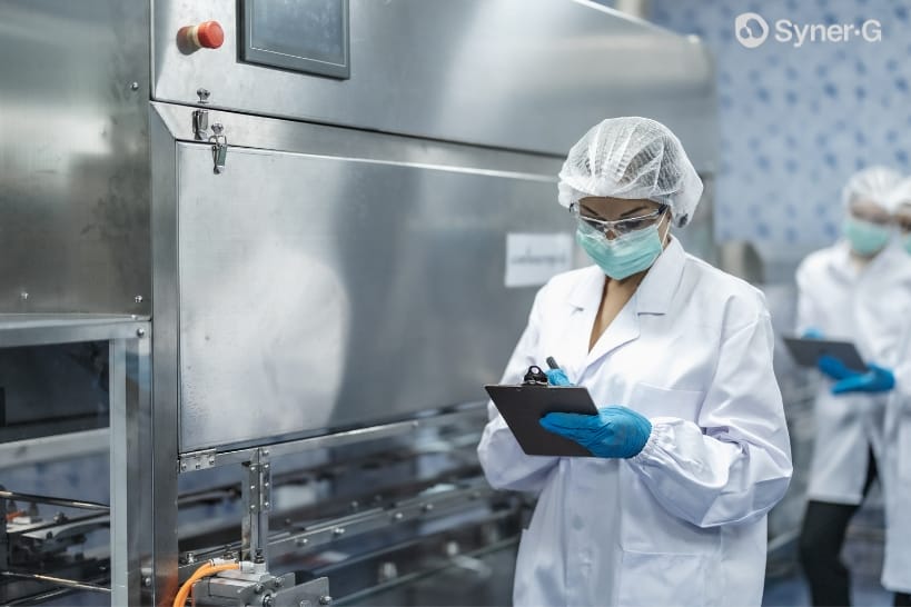 Biopharma professional documenting quality checks during a CDMO manufacturing inspection.