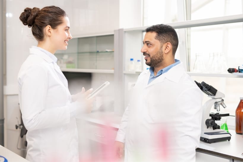Biopharma professionals discussing operational governance, joint KPIs, and continuity protocols in a laboratory.