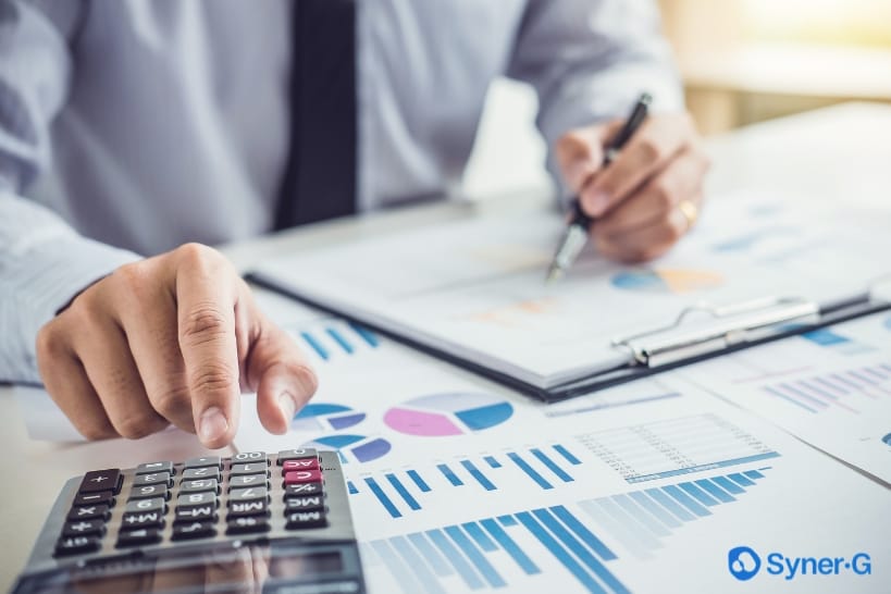Biopharma professional reviewing budgets and financial data while structuring MSAs and SOWs to control CDMO costs.